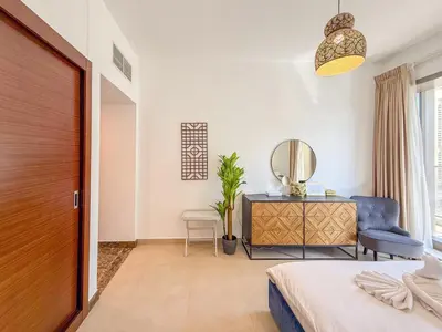 a bedroom with a bed and a mirror and a chair at Chic Stay in Sparkle Towers in Dubai