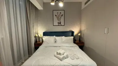 a bedroom with a bed with towels on it at Modern & Fully Furnished 1BR in Heart of JVC in Dubai
