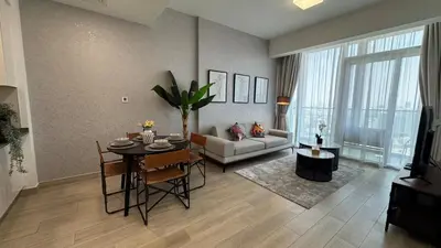 a living room with a table and a couch at Modern & Fully Furnished 1BR in Heart of JVC in Dubai