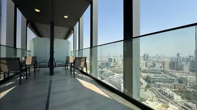 a balcony with chairs and a view of a city at Modern & Fully Furnished 1BR in Heart of JVC in Dubai
