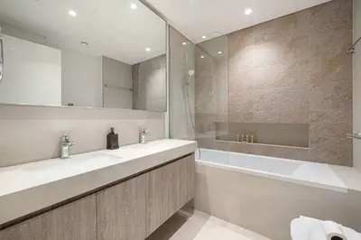 a bathroom with two sinks and a tub and a mirror at Luxury 2BR Downtown Dubai Near Dubai Mall in Dubai