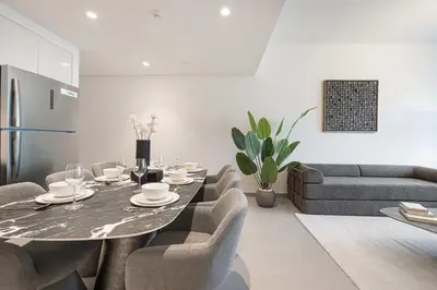 a living room with a table and chairs and a couch at Luxury 2BR Downtown Dubai Near Dubai Mall in Dubai