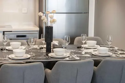 a dining room table with chairs and a refrigerator at Luxury 2BR Downtown Dubai Near Dubai Mall in Dubai