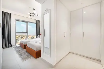 a white bedroom with a mirror and a bed at Prime Downtown Location 2BR Walk to Dubai Mall in Dubai
