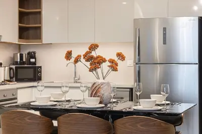 a kitchen with a table with wine glasses and a refrigerator at Prime Downtown Location 2BR Walk to Dubai Mall in Dubai