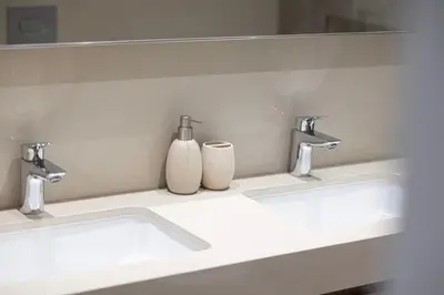 a bathroom with two sinks and two vases at Prime Downtown Location 2BR Walk to Dubai Mall in Dubai
