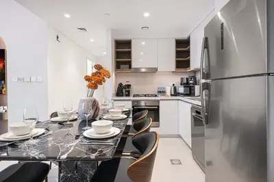 a kitchen with a table with chairs and a refrigerator at Prime Downtown Location 2BR Walk to Dubai Mall in Dubai