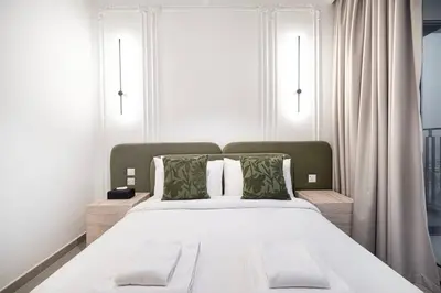 a bedroom with a large white bed with two windows at Elegant 2BR Downtown Dubai Walk to Dubai Mall in Dubai