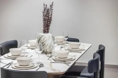 a dining room table with a vase of flowers on it at Elegant 2BR Downtown Dubai Walk to Dubai Mall in Dubai