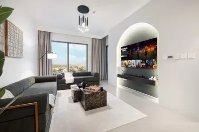 a living room with a couch and a tv at Elegant 2BR Downtown Dubai Walk to Dubai Mall in Dubai