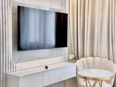 a room with a tv and a chair and a table at Signature Vista Studio Apartment in Dubai