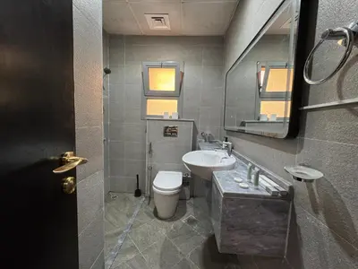 a bathroom with a sink and a toilet and a mirror at Signature Grand Studio Apartment in Dubai