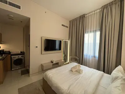 a hotel room with a bed and a television at Signature Grand Studio Apartment in Dubai