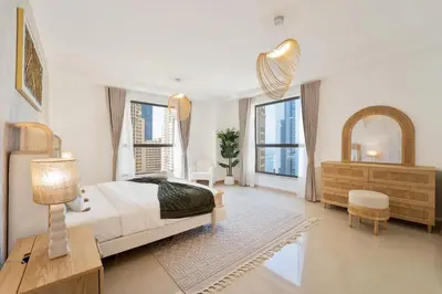 a bedroom with a bed and a dresser and windows at Elegant and Spacious 3-bedroom in JBR in Dubai