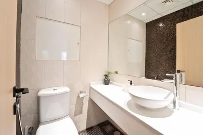 a bathroom with a sink and a toilet and a mirror at Elegant and Spacious 3-bedroom in JBR in Dubai