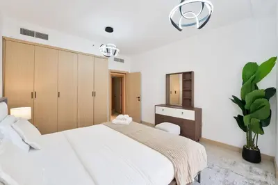 a bedroom with a large white bed and a plant at Elegant and Spacious 3-bedroom in JBR in Dubai