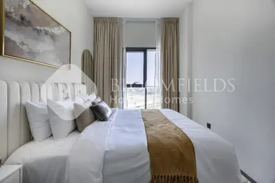 a bedroom with a white bed with a window at Bloomfields Cozy 1br In Rukan in Dubai