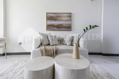 a living room with a couch and two circular tables at Bloomfields Cozy 1br In Rukan in Dubai