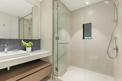 a bathroom with a glass shower and a sink at Silkhaus Lavish 2BDR Retreat at Dubai Creek Harbour in Dubai