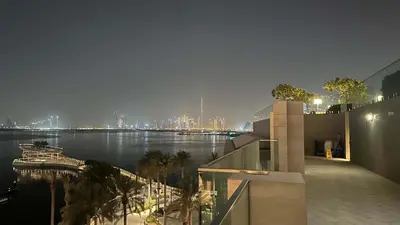 a view of a river at night from a building at Silkhaus Lavish 2BDR Retreat at Dubai Creek Harbour in Dubai