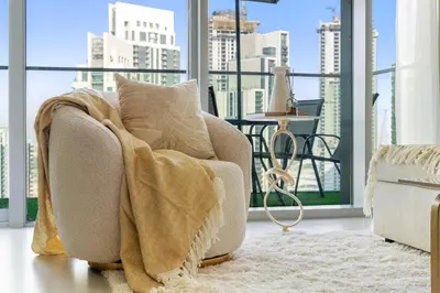 a living room with a couch with a blanket at Silkhaus Lavish 2BDR Retreat at Dubai Creek Harbour in Dubai