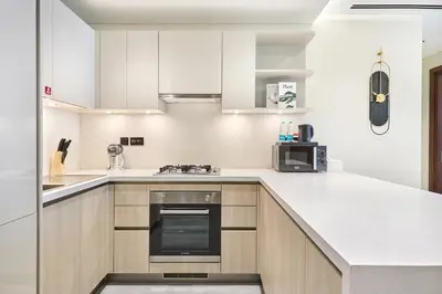 a kitchen with white cabinets and a stove top oven at STAY BY LATINEM Luxury 2 BR Plus Maid Holiday Home CD 0208 Near Burj Khalifa in Dubai