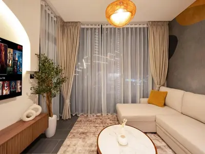 a living room with a couch and a table at Royal Vista - Stunning Boho Style 1BR with 5 Star Amenities in Dubai