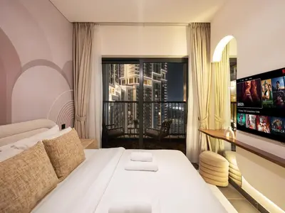 a hotel room with a bed and a flat screen tv at Royal Vista - Stunning Boho Style 1BR with 5 Star Amenities in Dubai