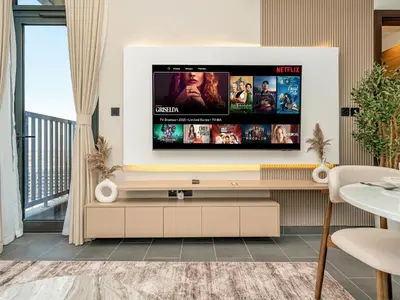 a living room with a flat screen tv on a wall at Royal Vista - Stunning Boho Style 1BR with 5 Star Amenities in Dubai