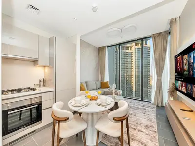 a kitchen and living room with a table and chairs at Royal Vista - Stunning Boho Style 1BR with 5 Star Amenities in Dubai
