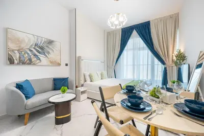 a living room with a table and a couch at Bright studio oplaz by Danube Near Miracle Garden in Dubai