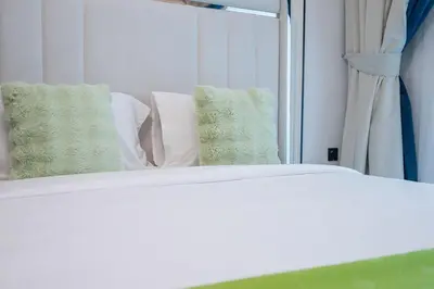 a close up of a bed with a mirror at Bright studio oplaz by Danube Near Miracle Garden in Dubai