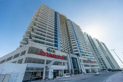 a large building with a sign on the side of it at Bright studio oplaz by Danube Near Miracle Garden in Dubai