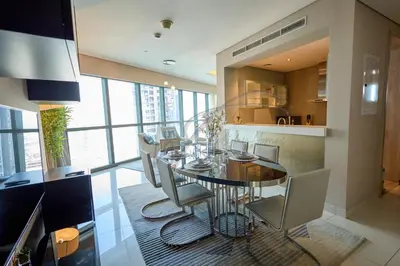 a dining room with a glass table and chairs at DAMAC Paramount Towers 2BHK by WS Holiday Homes in Dubai