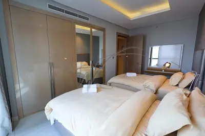 a hotel room with two beds and a bedroom at DAMAC Paramount Towers 2BHK by WS Holiday Homes in Dubai