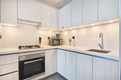 a kitchen with white cabinets and a sink at STAY BY LATINEM Luxury 2BR Holiday Home CB 1215 Near Burj Khalifa in Dubai