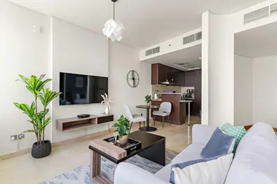 a living room with a white couch and a tv at Silkhaus Gallery Studio at Sky Gardens in DIFC in Dubai