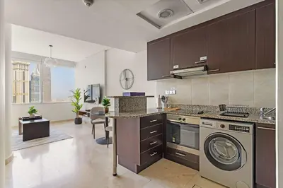 a kitchen with a washer and a dishwasher at Silkhaus Gallery Studio at Sky Gardens in DIFC in Dubai