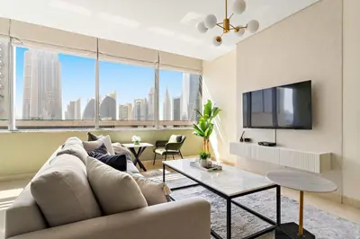 a living room with a couch and a tv at Silkhaus Premium 1BDR Stay with DIFC Views in Dubai