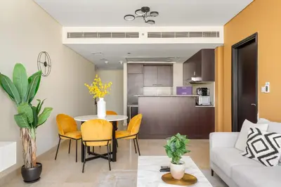 a living room with a white couch and a table and chairs at Silkhaus Classic 1BDR in DIFC at Sky Gardens in Dubai