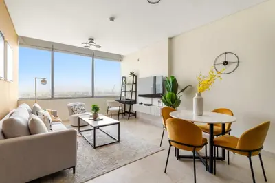 a living room with a couch and a table and chairs at Silkhaus Classic 1BDR in DIFC at Sky Gardens in Dubai