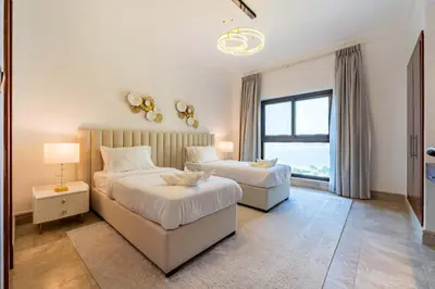 a bedroom with two beds and a window at TRPS - Fairmont North Residences, Palm Jumeirah - Luxurious 2BR plus Maids, Sea and Harbour View in Dubai