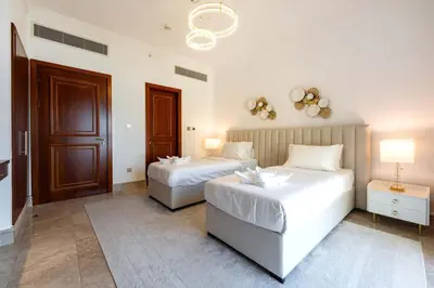 a bedroom with two beds and a door at TRPS - Fairmont North Residences, Palm Jumeirah - Luxurious 2BR plus Maids, Sea and Harbour View in Dubai