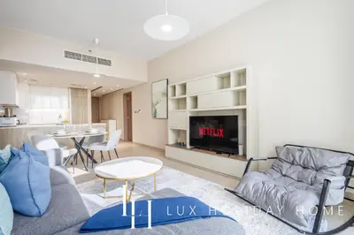 a living room with a couch and a tv at LUX LIV Contemporary Marina View Suite 2 in Dubai