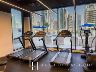 a gym with two treadmills in front of a window at LUX LIV Contemporary Marina View Suite 2 in Dubai