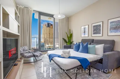 a bedroom with a large bed and a tv at LUX LIV Contemporary Marina View Suite 2 in Dubai