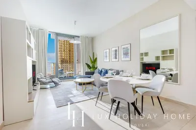 a dining room and living room with a table and chairs at LUX LIV Contemporary Marina View Suite 2 in Dubai