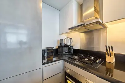a kitchen with a stove and a microwave at FAM Living - 1 Bedroom Canal View in DAMAC Maison Prive in Dubai