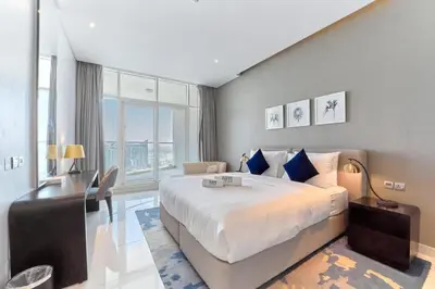 a bedroom with a large bed and a large window at FAM Living - 1 Bedroom Canal View in DAMAC Maison Prive in Dubai