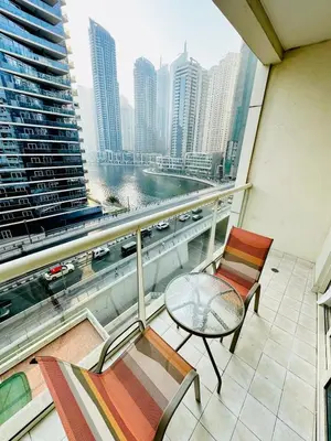 a balcony with two chairs and a glass table at Marina View Towers - Dubai Marina Walk Access - View - 1BHK - Marsa in Dubai